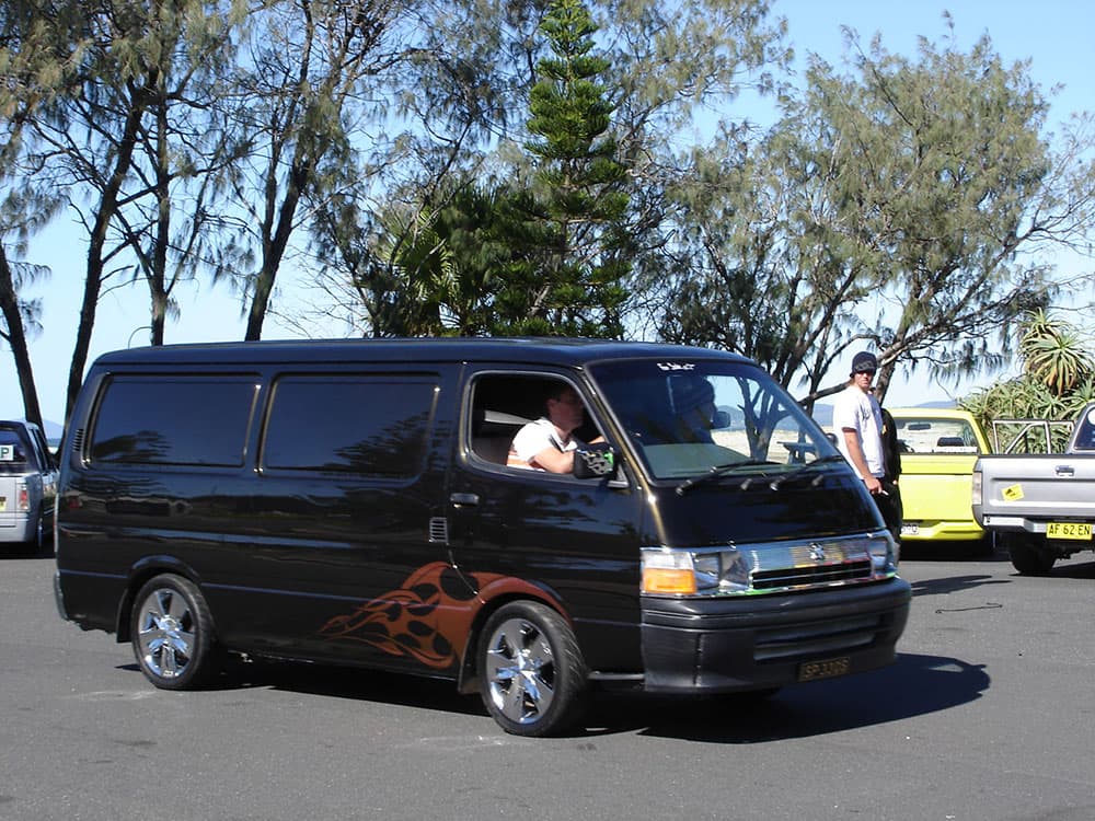 Black Toyota Hiace van with orange flame graphics and chrome wheels at coastal cruise event at Half Way Havoc 2006 Nambucca Heads NSW - Minitruck Show Photos