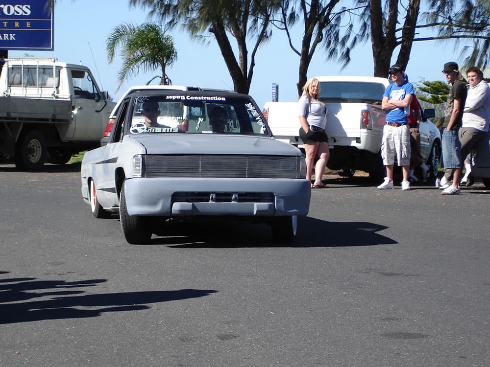 White bagged Mazda minitruck with extreme ground clearance and spectators at coastal cruise event at Half Way Havoc 2006 Nambucca Heads NSW - Minitruck Show Photos