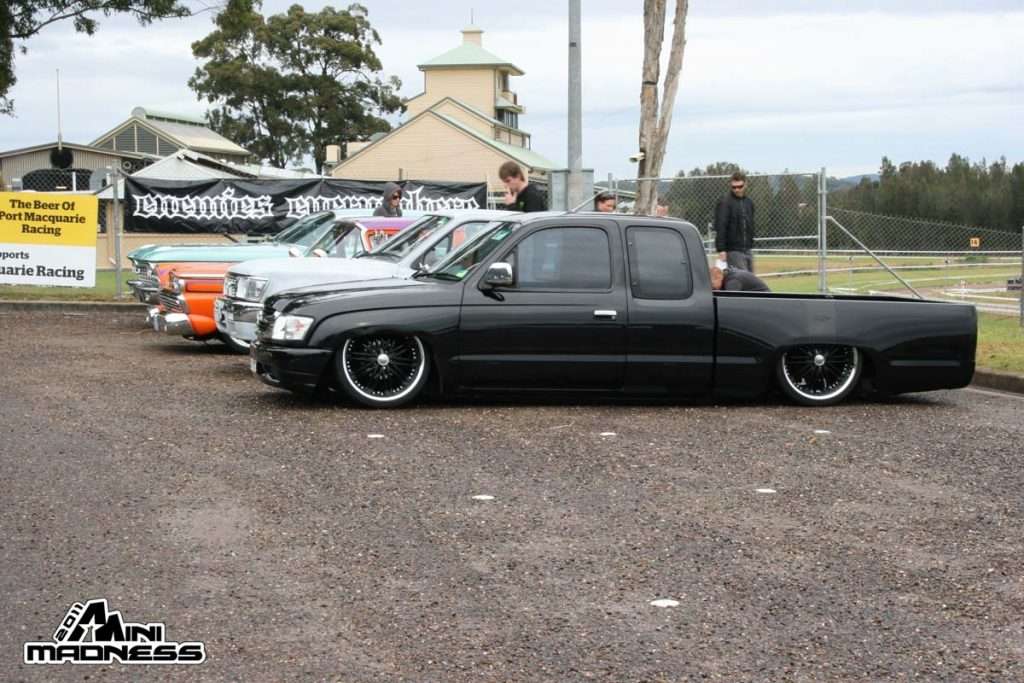 Black extended cab minitruck with chrome wire wheels and Bioshock Riders banner at Mini Madness 2011