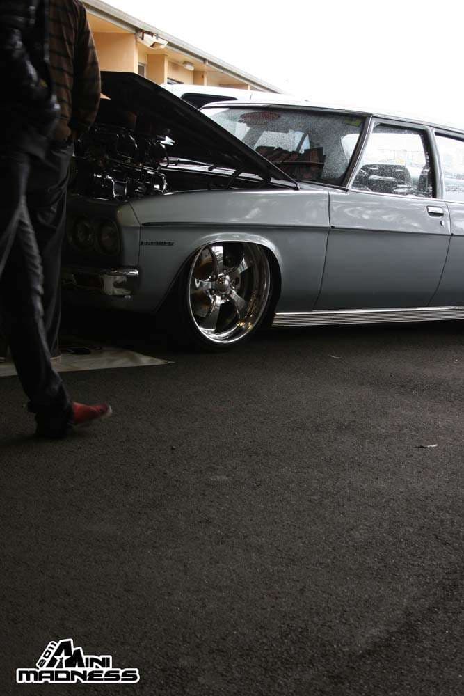Grey slammed Australian wagon with hood open and large chrome wheels at Mini Madness 2011