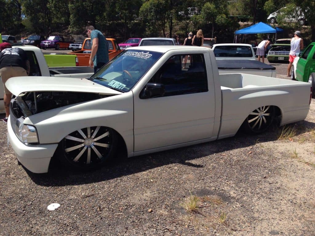 White minitruck with turbine wheels and shaved engine bay displaying custom work at Mini Madness 2014