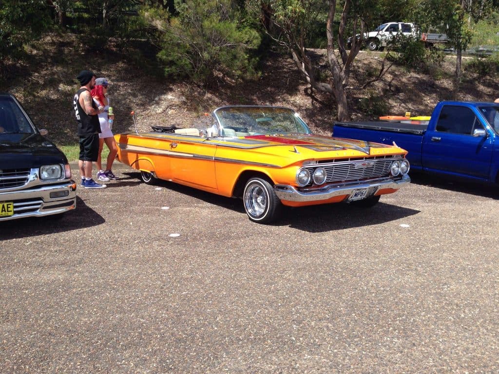 Orange and yellow 1961 Chevrolet Impala convertible with white interior at Port Macquarie Mini Madness show