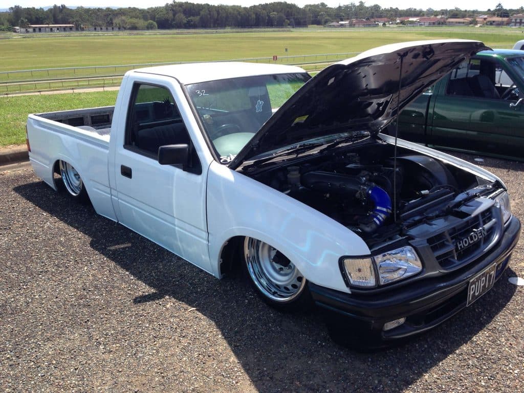 White slammed Holden Rodeo with hood open showing blue engine bay details at Mini Madness 2014 raceway