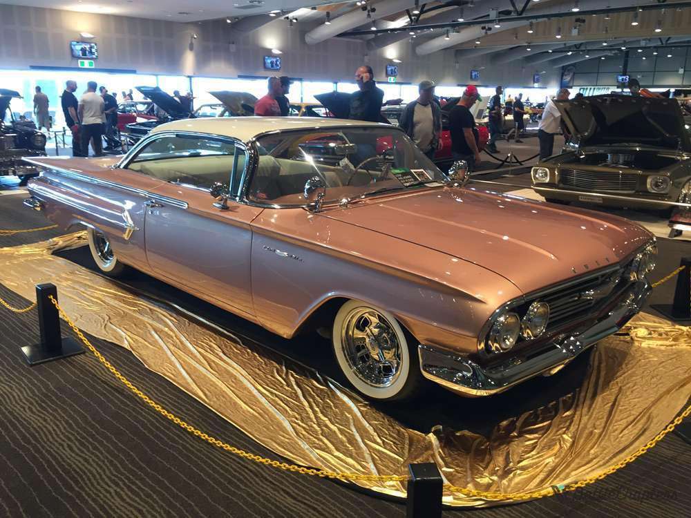 Rose 1960 Chevrolet Impala convertible slammed on chrome wheels with white wall tires at Sydney Hot Rod Expo indoor display